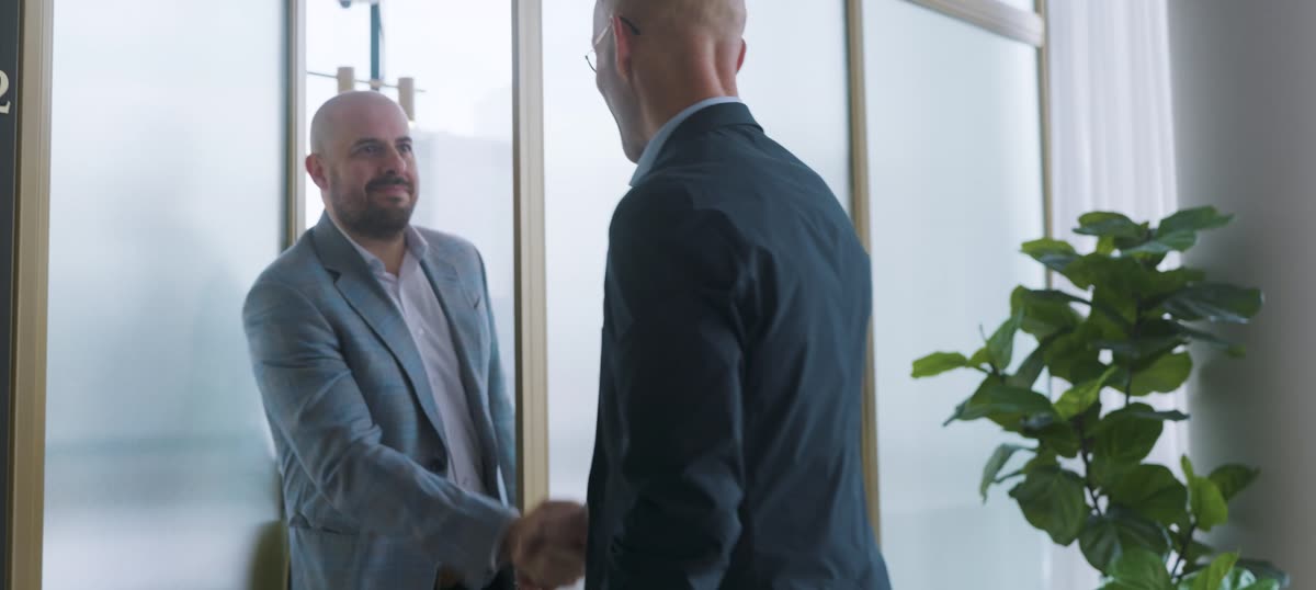 Thierry Nantel shaking hands with a client in a downtown office